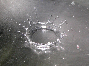 Water drop striking the bottom of a metal kitchen sink